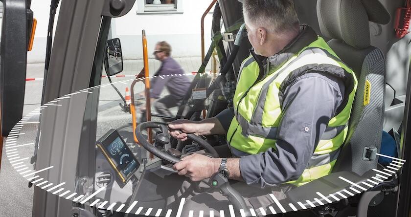 View of a wheeled excavator operator with graphics showing his wide range of view out of the cab.