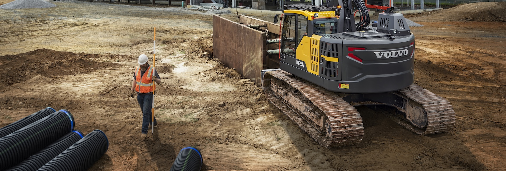 An operator idling a Volvo excavator on a construction jobsite while he’s outside the cab.