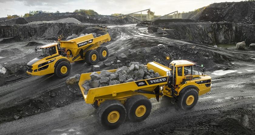 Two Volvo ADTs hauling rock in a quarry.