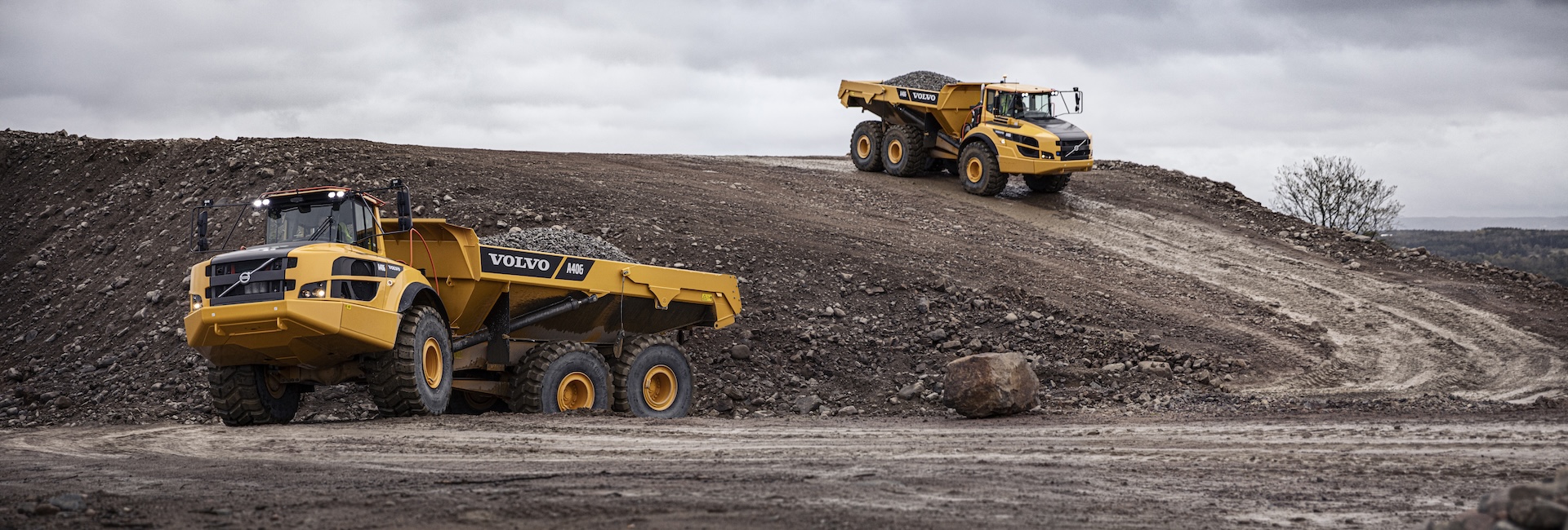 Two Volvo articulated haulers hauling rock in a quarry