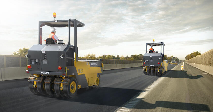 Two Volvo PT125C pneumatic tire compactors compacting asphalt on a new urban highway.