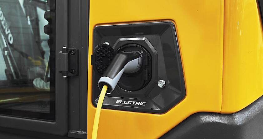 A close up of a JPlug charging a piece of Volvo electric equipment.