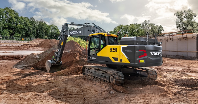 A Volvo EC230 Electric midsize excavator digging a trench in construction.