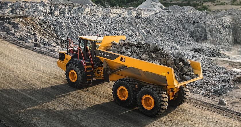 Le nouveau tombereau articulé Volvo A50 sur une route de transport avec un chargement de roches dans une carrière.