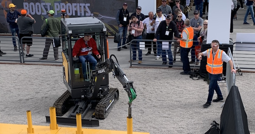 A CONEXPO 2023 attendee operating a Volvo electric mini excavator during an operator competition.
