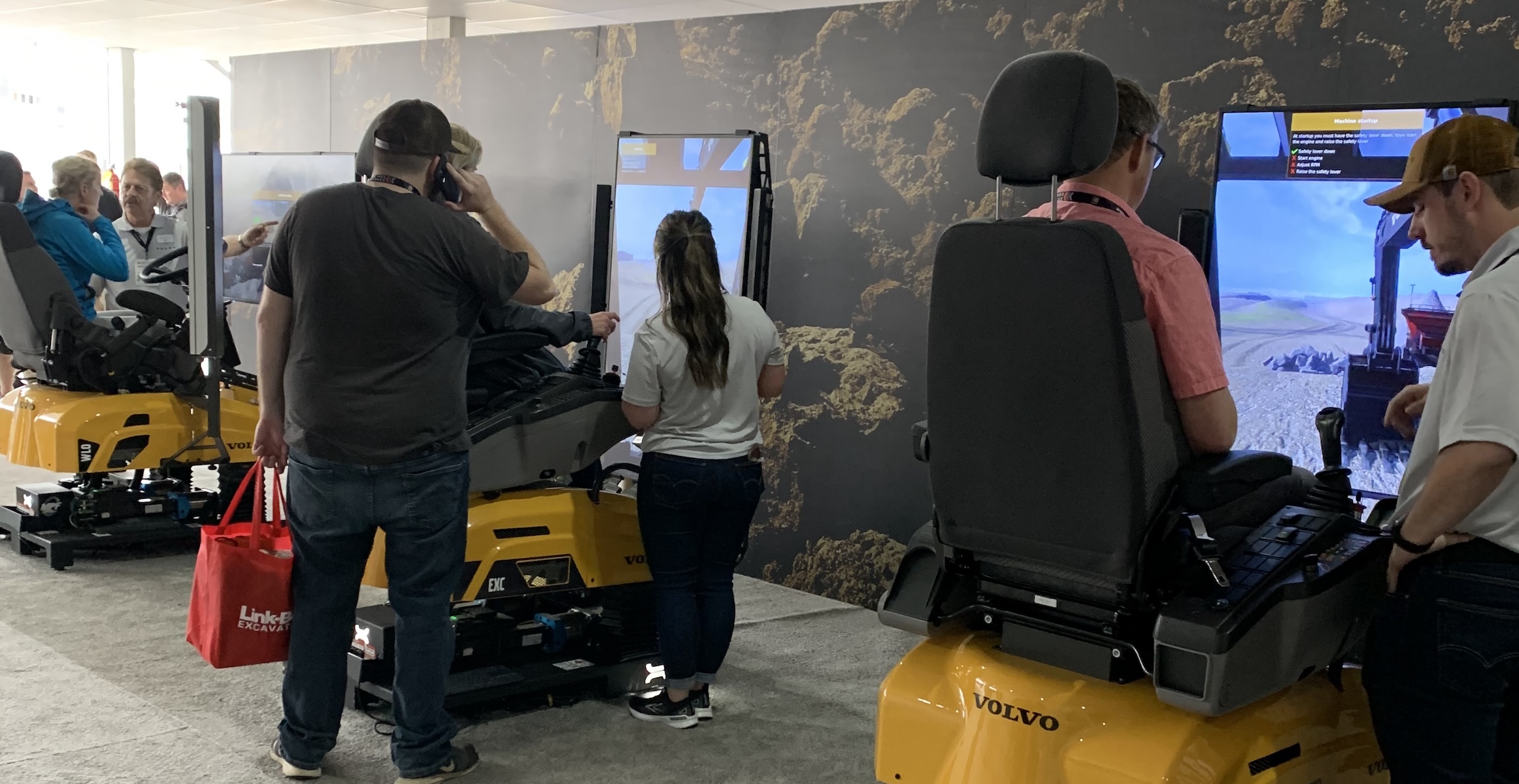CONEXPO/CON-AGG attendees trying out three different Volvo simulators at the 2023 show.