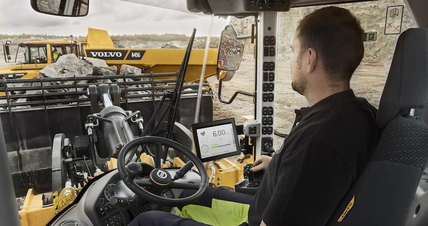 An operator using Volvo Load Assist to load rock into a Volvo A45G articulated dump truck.