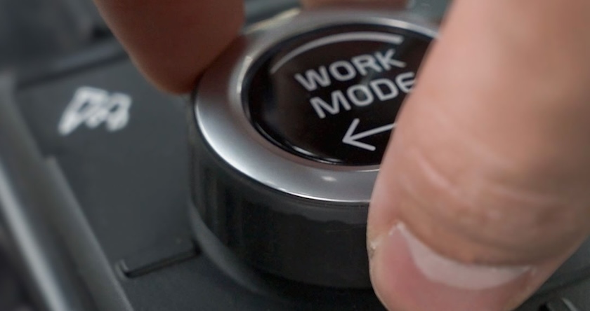A close-up of an operator turning the work modes dial on a new Volvo excavator.
