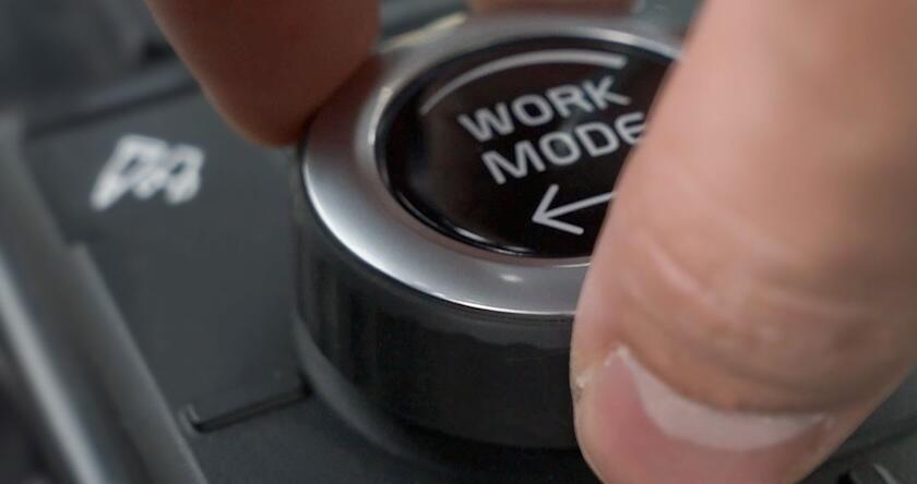 A close-up of an operator turning the work modes dial on a new Volvo excavator.