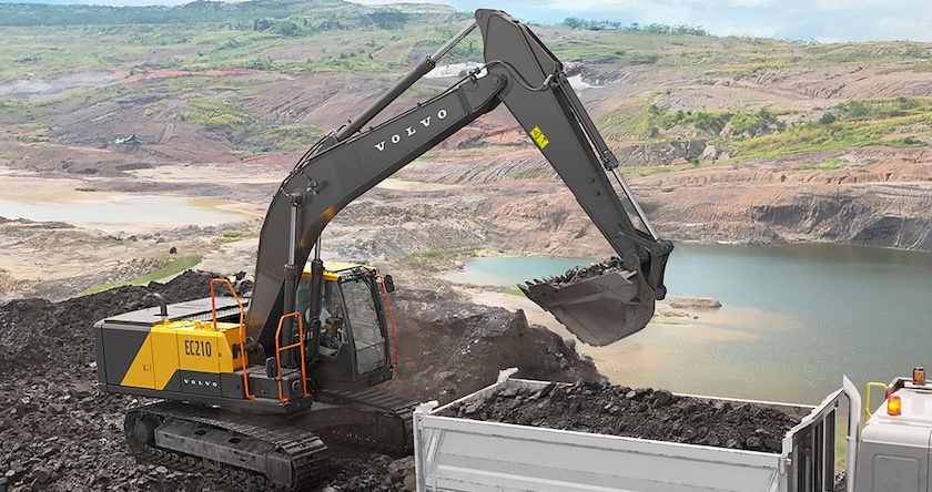 A Volvo EC210 crawler excavator loading a truck in a quarry.