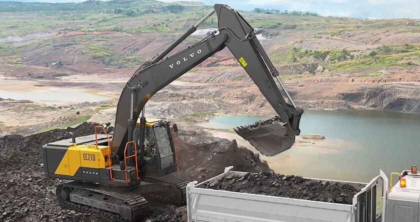 A Volvo EC210 crawler excavator loading a truck in a quarry.