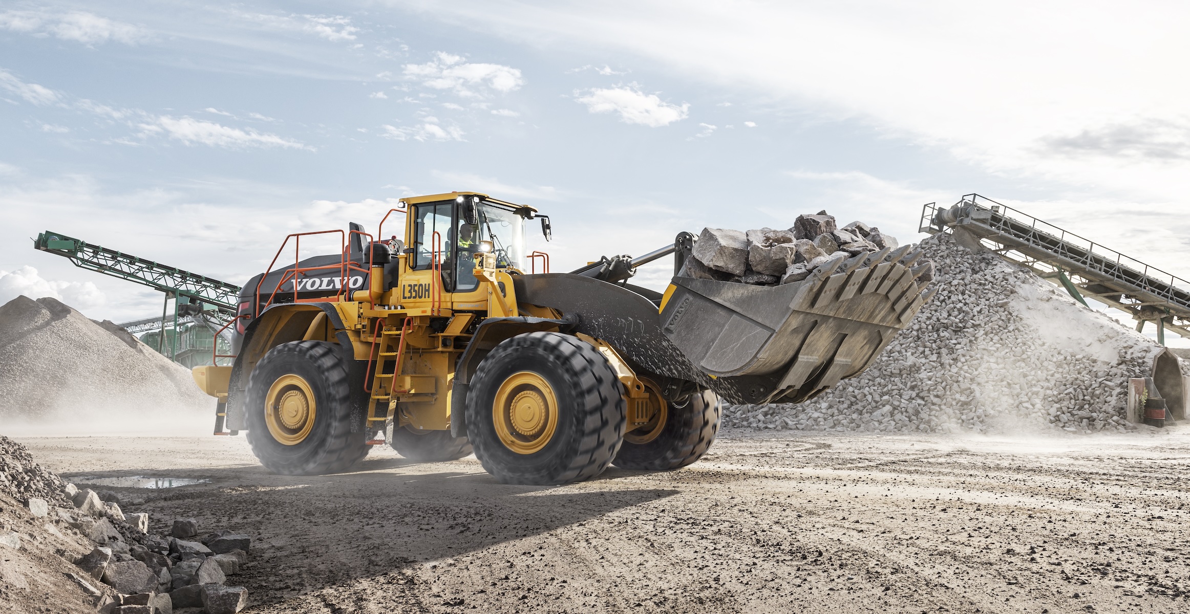 A Volvo L350 wheel loader hauling rock to a crusher on a quarried aggregates site.