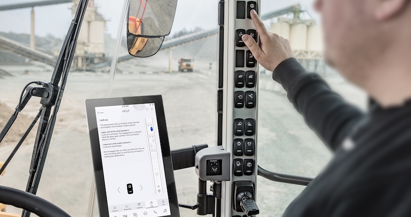 A wheel loader operator using Volvo Load Assist with the Co-Pilot display present.