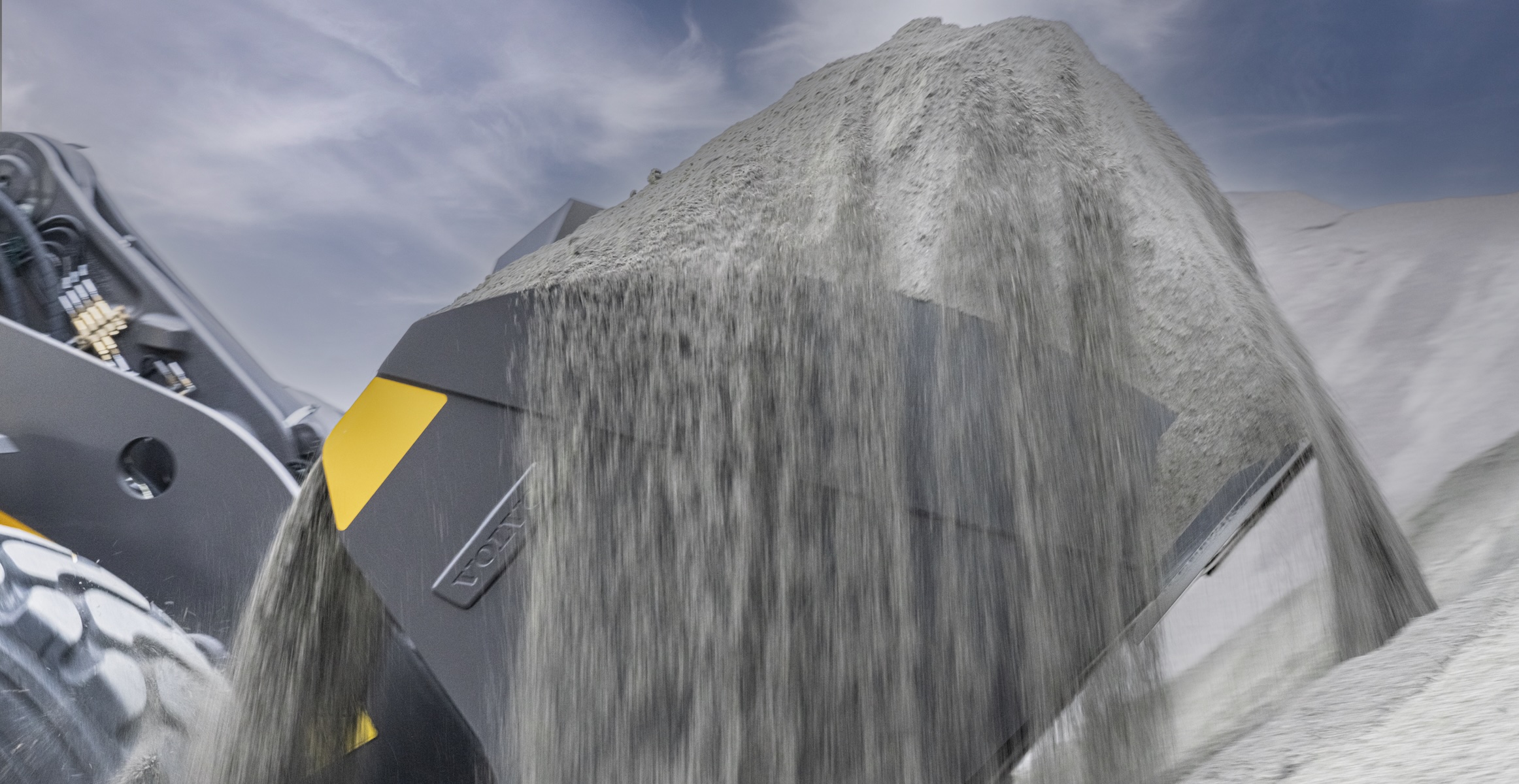 Close up of a Volvo wheel loader scooping sand using Auto Bucket Fill.