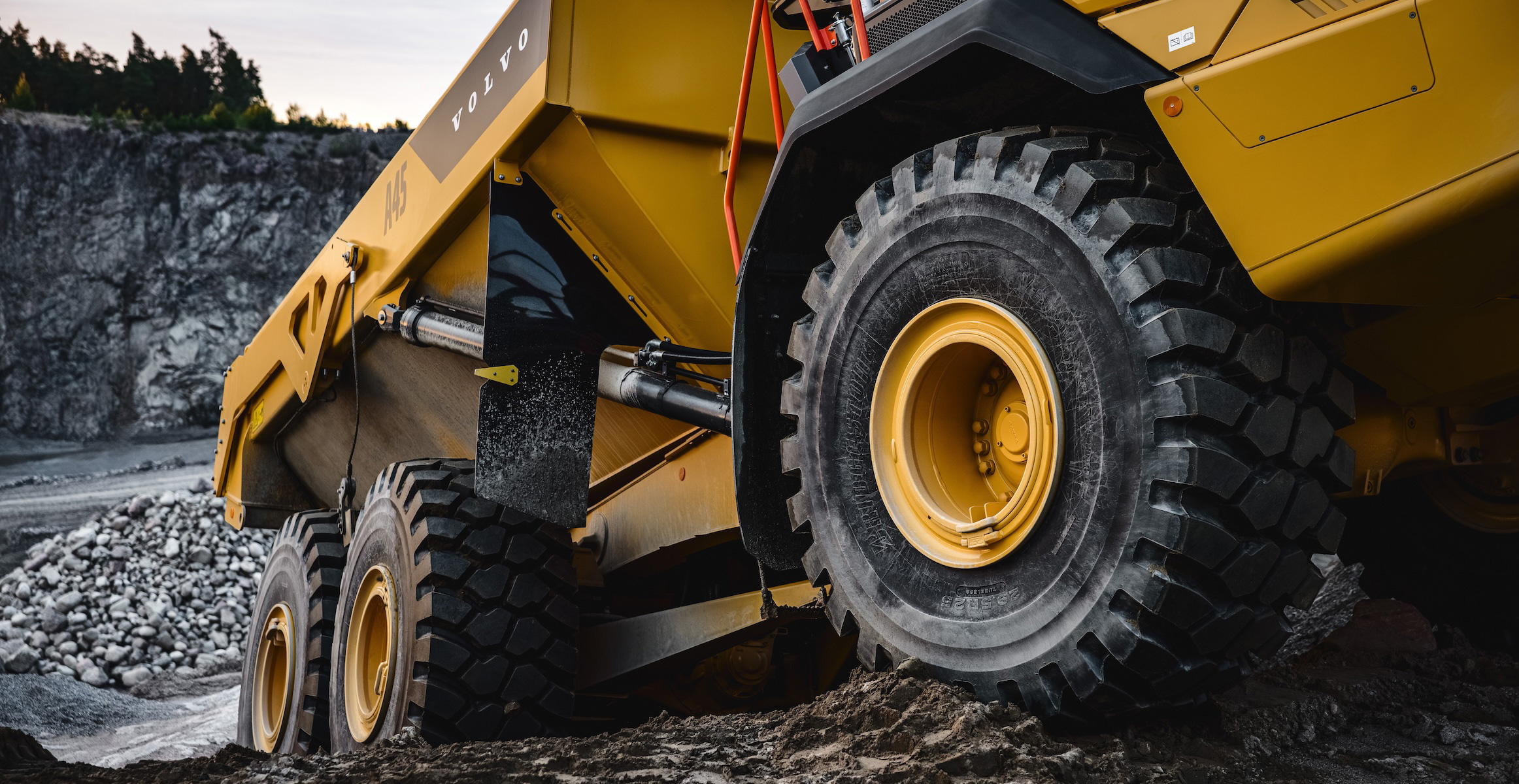 Close up of a Volvo A45 articulated haul truck driving on rough terrain in a quarry.