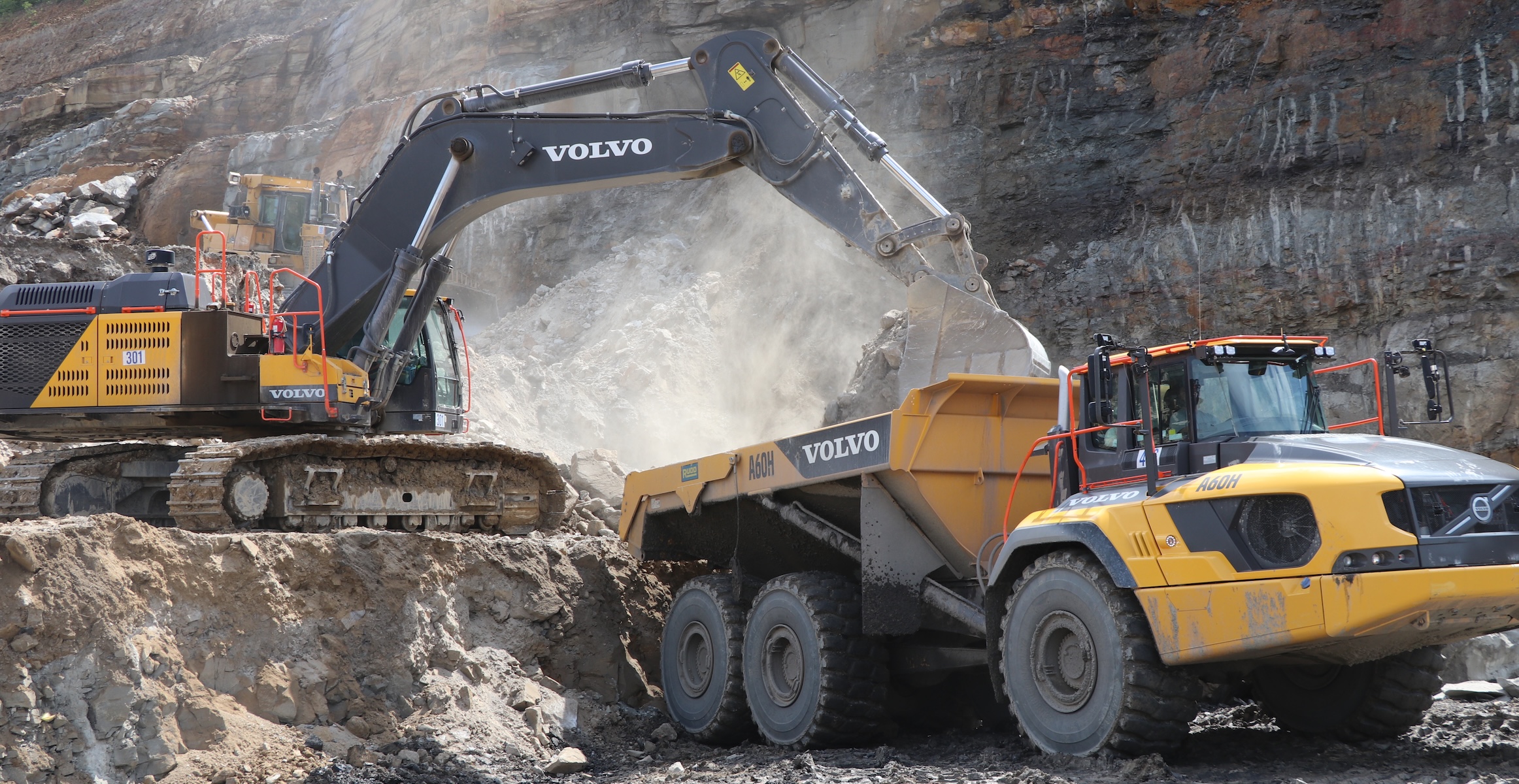 A Volvo excavator loading overburden into a Volvo A60 quarry dump truck.
