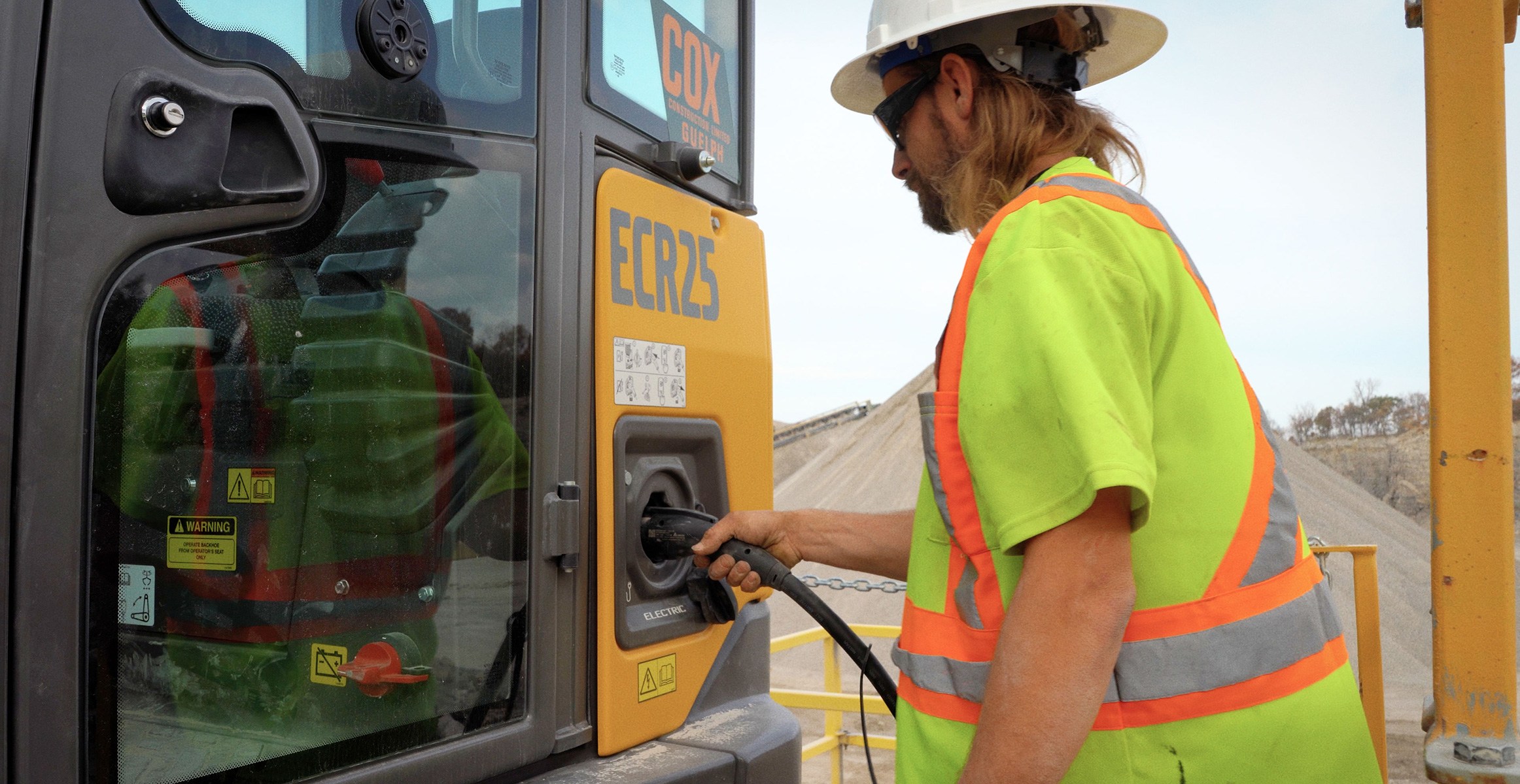 Cox Construction charging a Volvo ECR25 electric compact excavator.