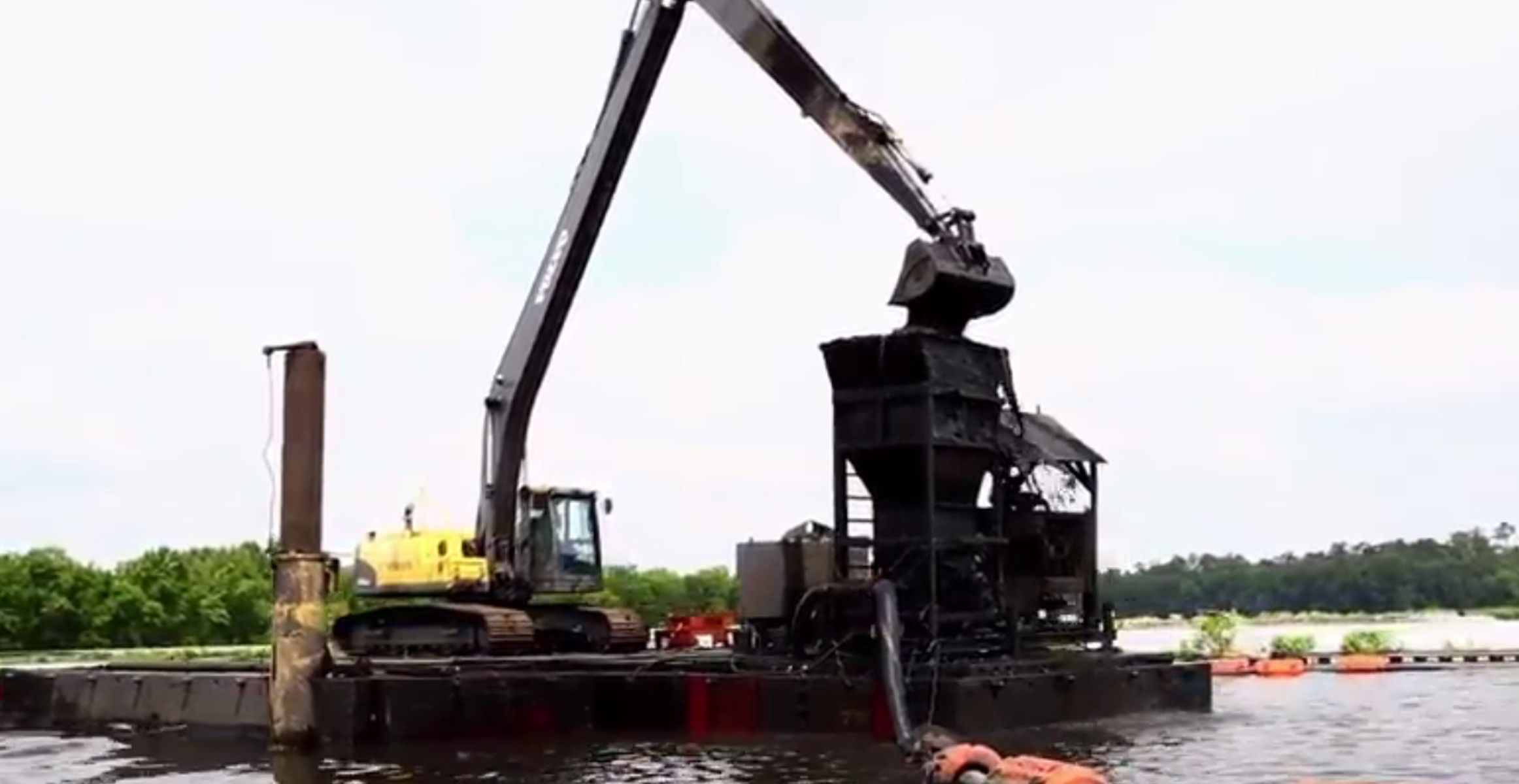 Volvo EC240C long-reach excavator scoops sediment at a mil wastewater treatment facility in Louisiana