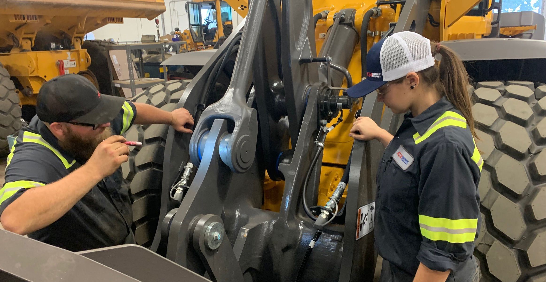 J-Tech Institute graduates and Alta Equipment Company technicians examine a wheel loader at Alta’s Jacksonville location.