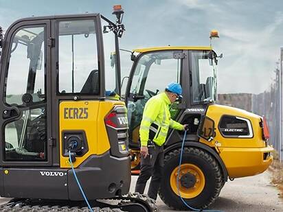 A Volvo L25 electric wheel loader charging on a portable charger on a remote jobsite.