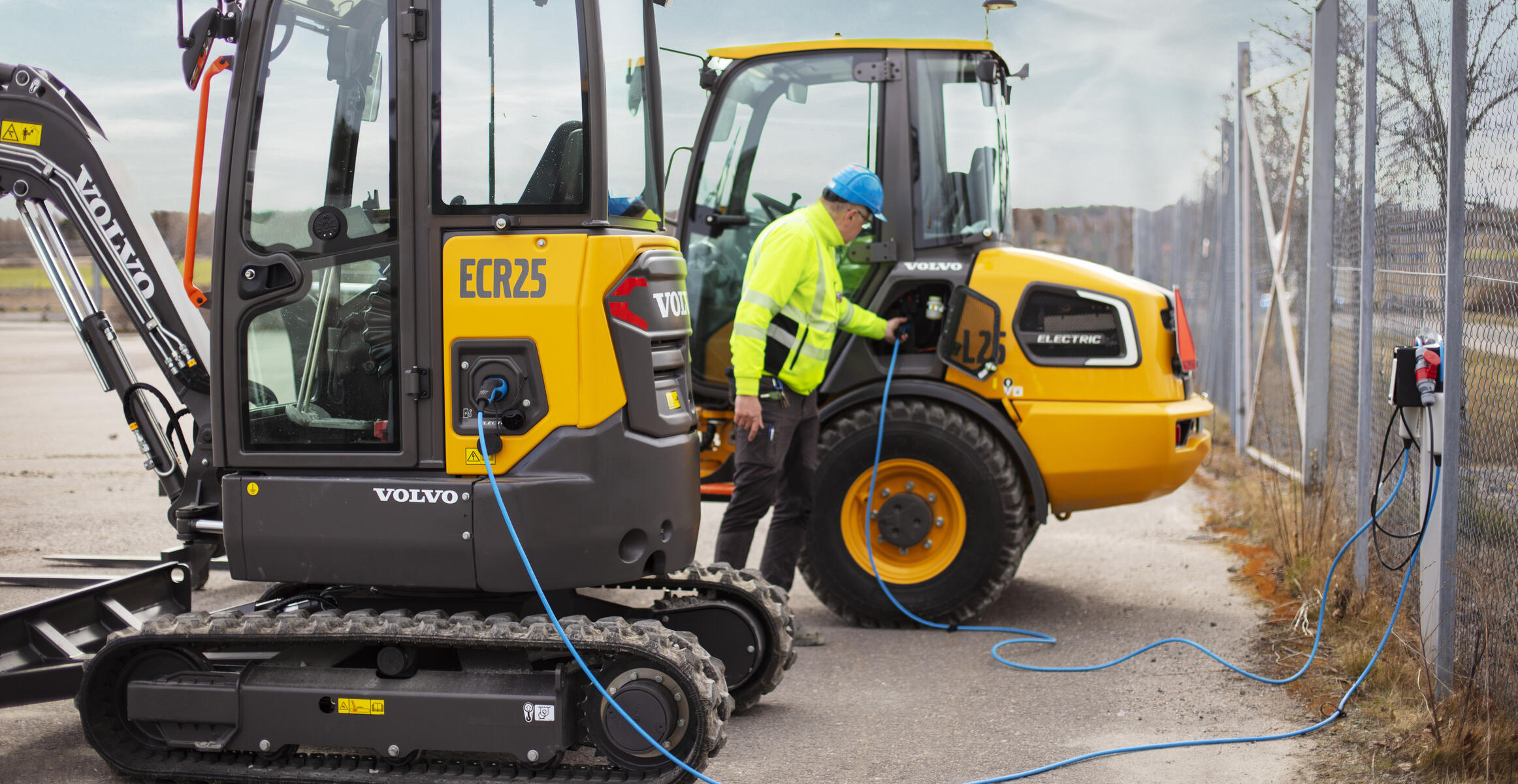 A Volvo L25 electric wheel loader charging on a portable charger on a remote jobsite.