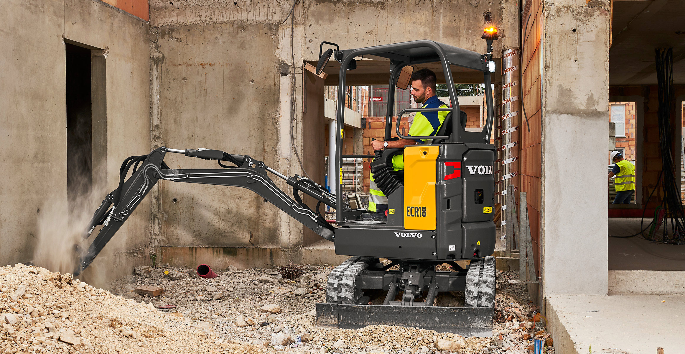 A Volvo compact electric excavator working indoors.