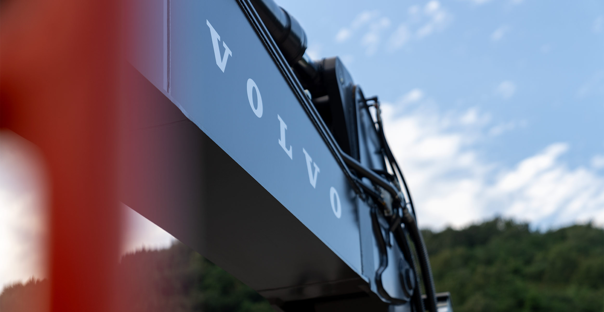 Close-up of the Volvo logo on the boom of a new Volvo excavator.