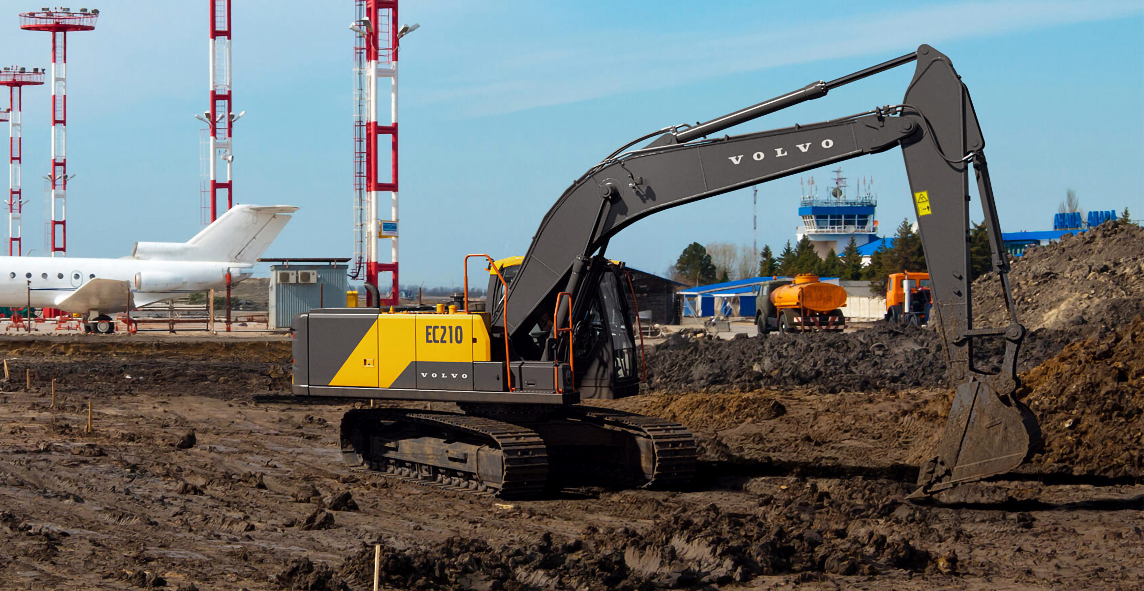 A Volvo EC210 excavator working in site prep at an airport.