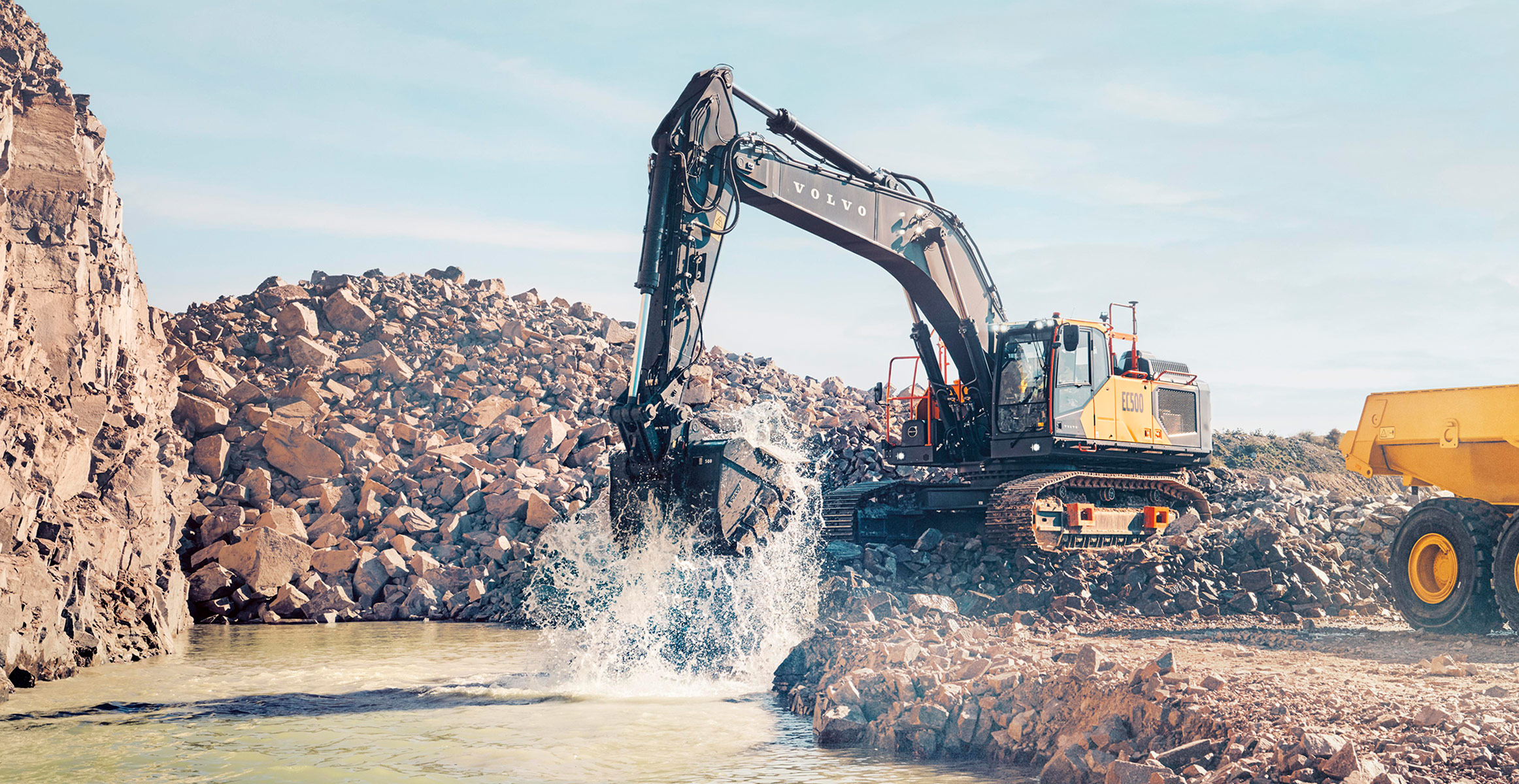 A Volvo EC500 excavator loading rock into a Volvo ADT in a quarry.