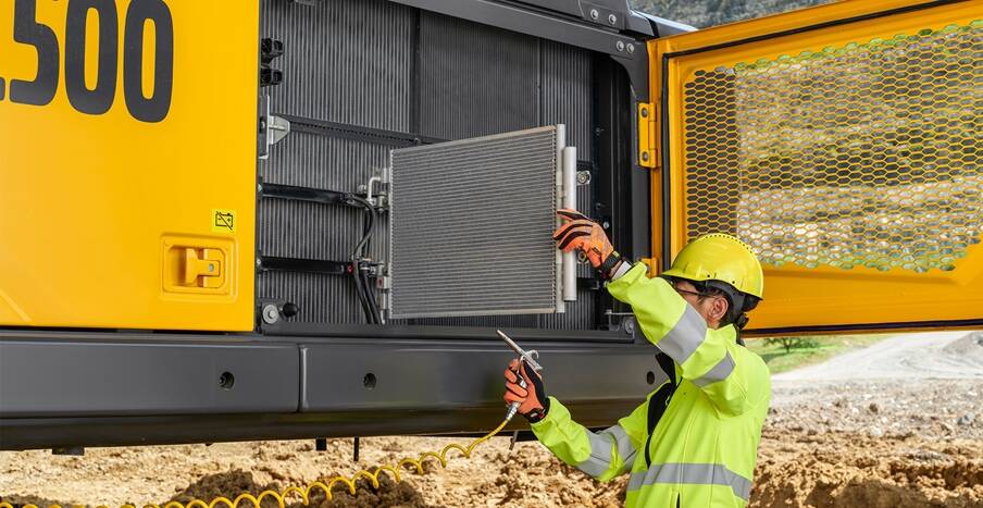 A service tech providing maintenance on a Volvo EC500 excavator. 