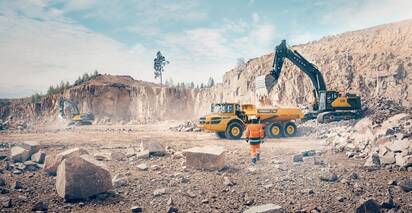 A Volvo excavator loading a Volvo articulated truck in a quarry.