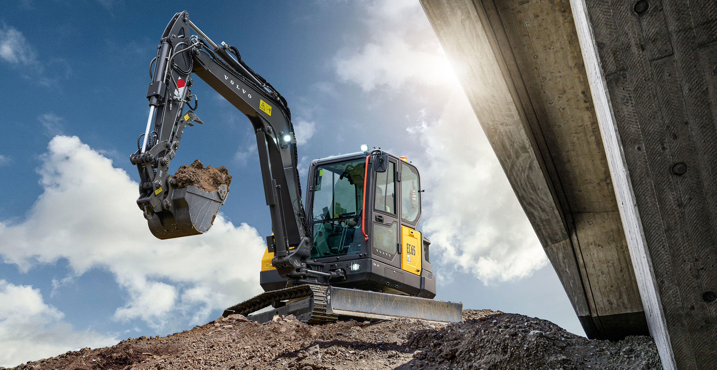 A Volvo mini excavator moving dirt in construction.
