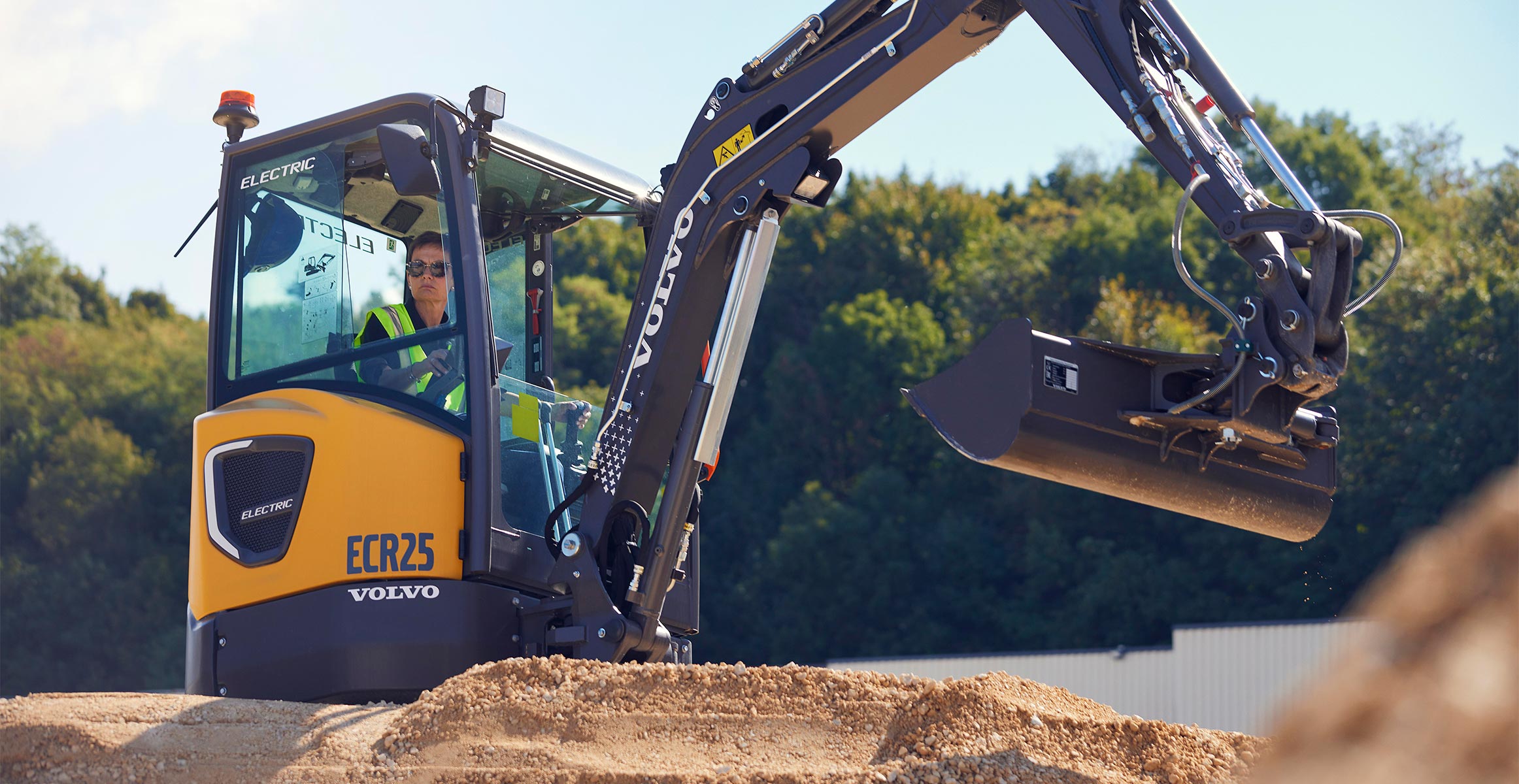 A Volvo electric excavator moving dirt in construction.