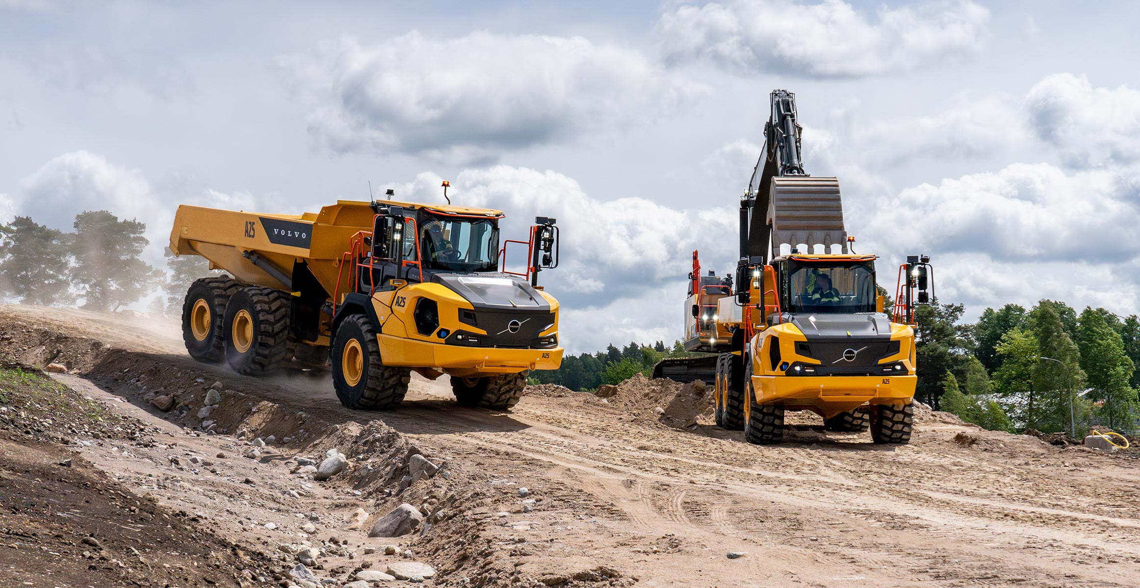 Volvo excavator loading two articulated dump trucks. 