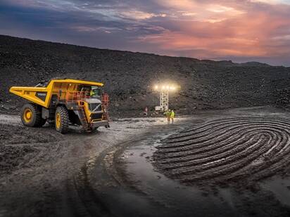 A Volvo rigid haul truck in a quarry with a thumbprint design carved into the ground in front of it.