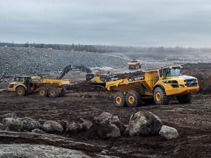 Volvo excavator and haulers on a jobsite eligible for Volvo financing offers on heavy equipment loans, leases and low rates.