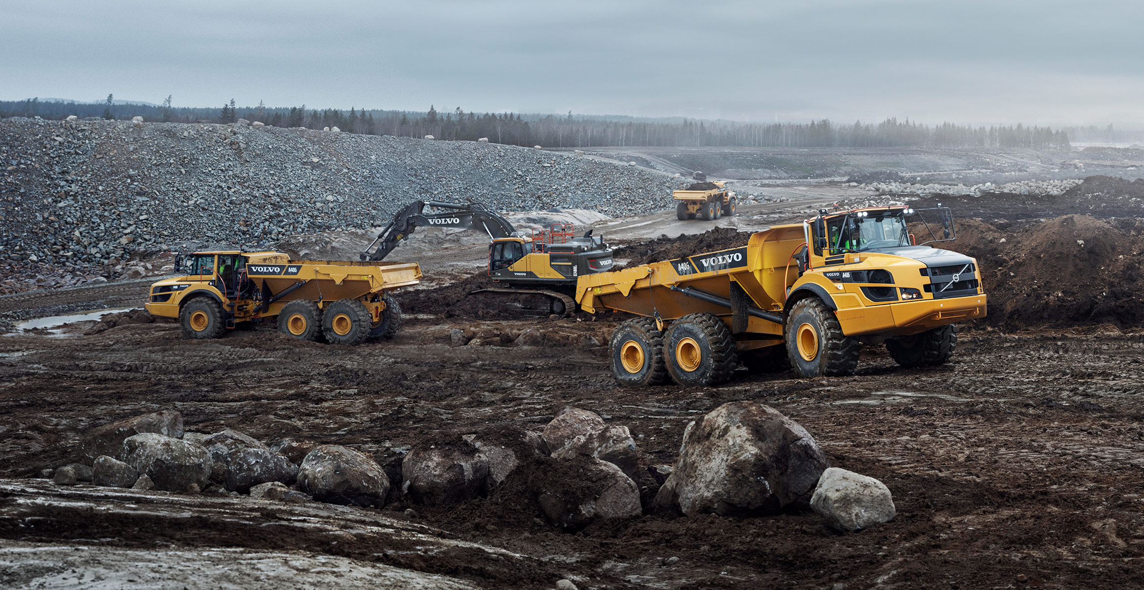 Volvo excavator and haulers on a jobsite eligible for Volvo financing offers on heavy equipment loans, leases and low rates.