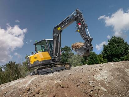 A Volvo EC65 mini excavator moving dirt on a construction jobsite.