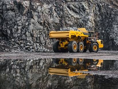 A Volvo A45 articulated dump truck driving next to water in a quarry.