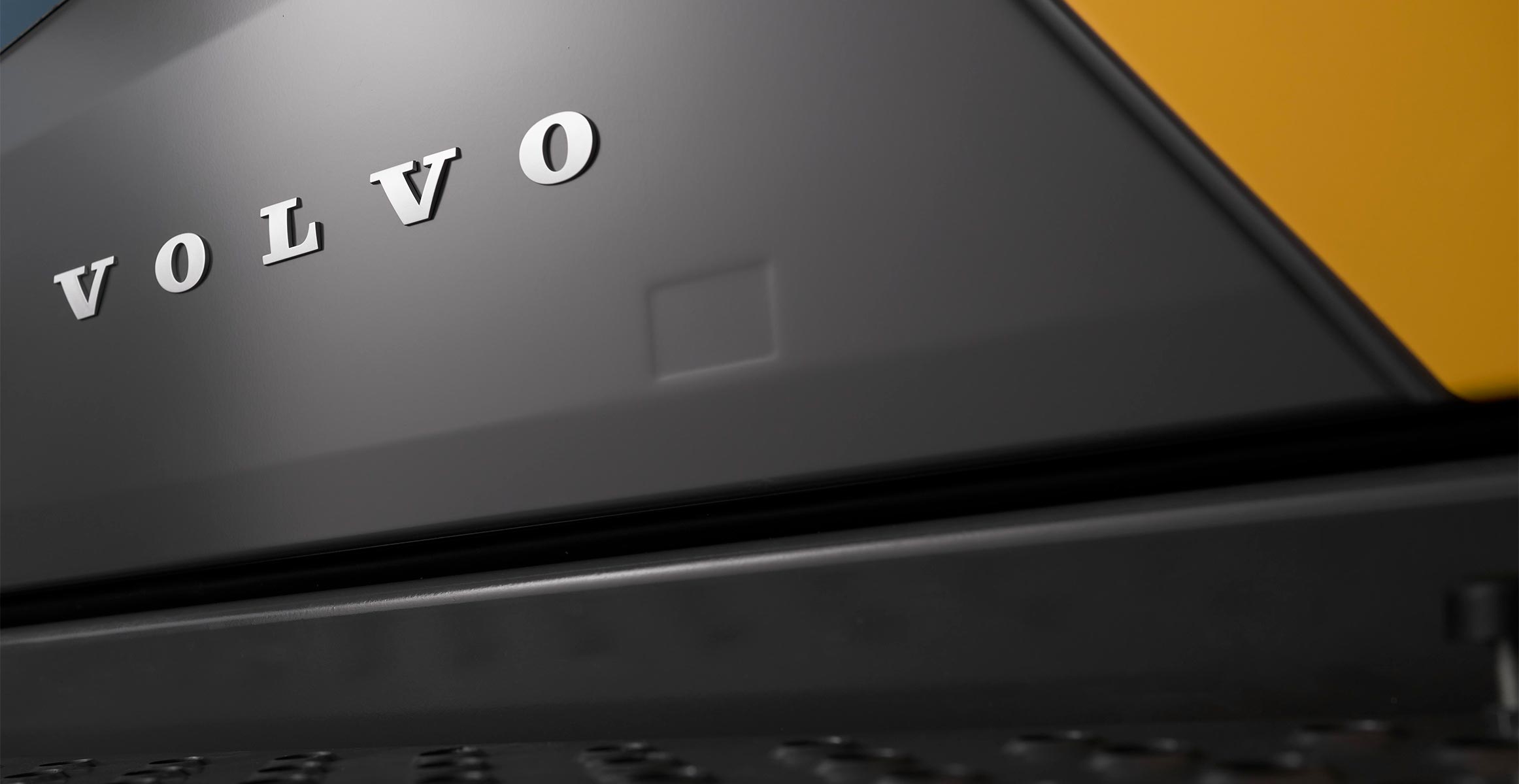A close-up of the Volvo emblem on the side of a new Volvo excavator.
