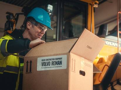En mand åbner en pakke med reservedele fra Volvo CE.