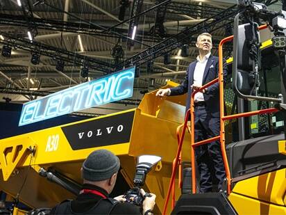 CEO of Volvo CE, Melker Jernberg, in front of a compact electric excavator.