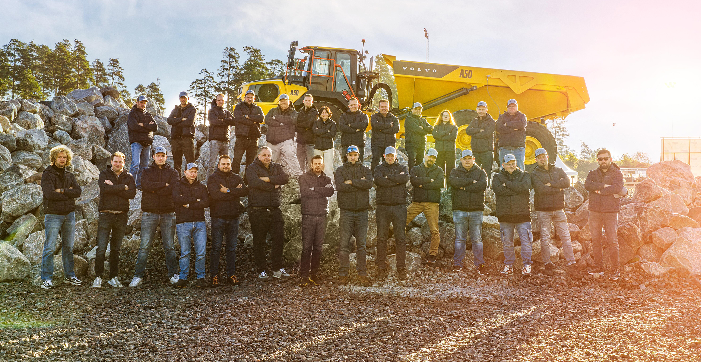 Operators Club Final contestants lined up in front of a Volvo dump truck.