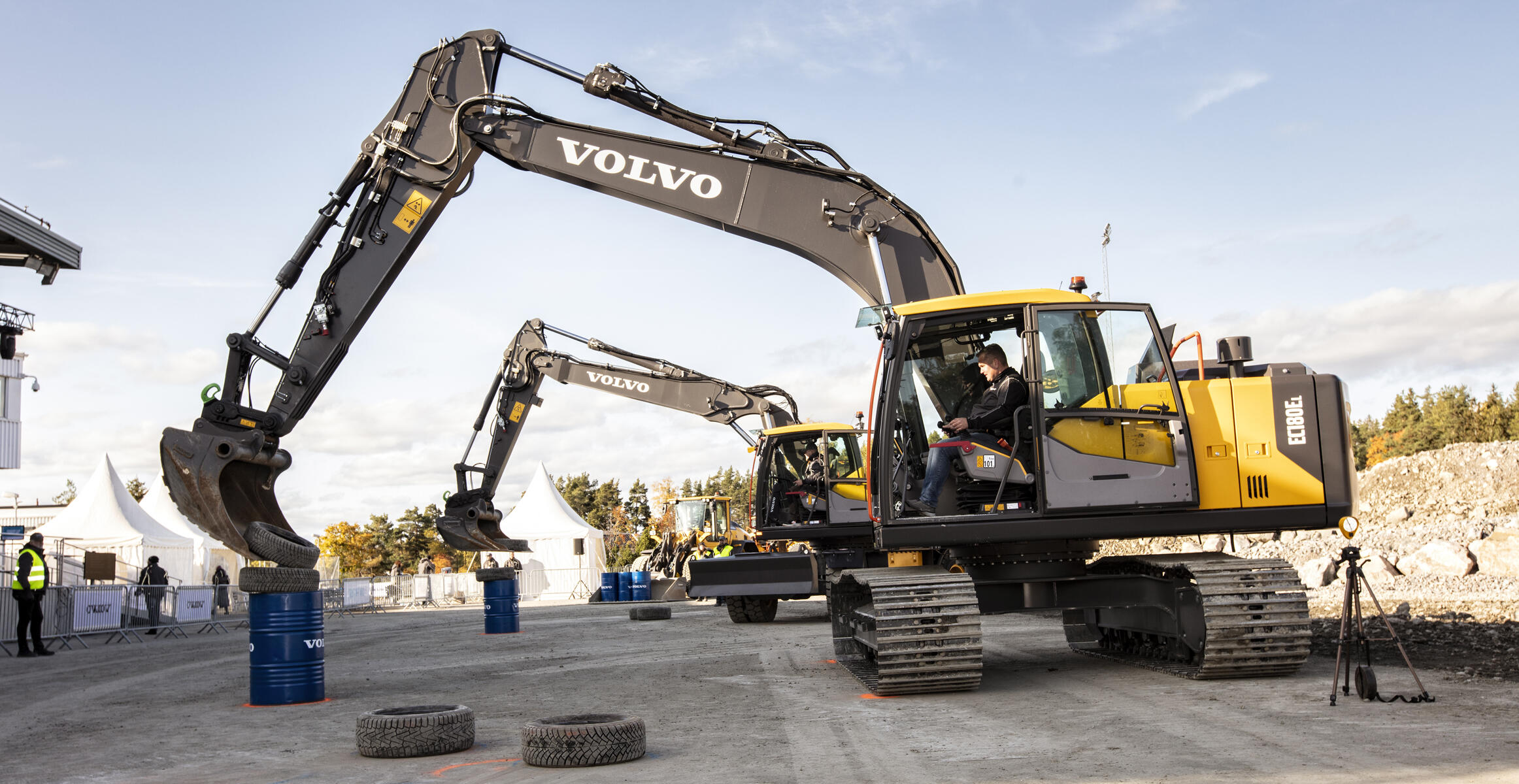 Reifen stapeln mit einem Volvo-Mobilbagger EW220E und einem Kettenbagger EC160E