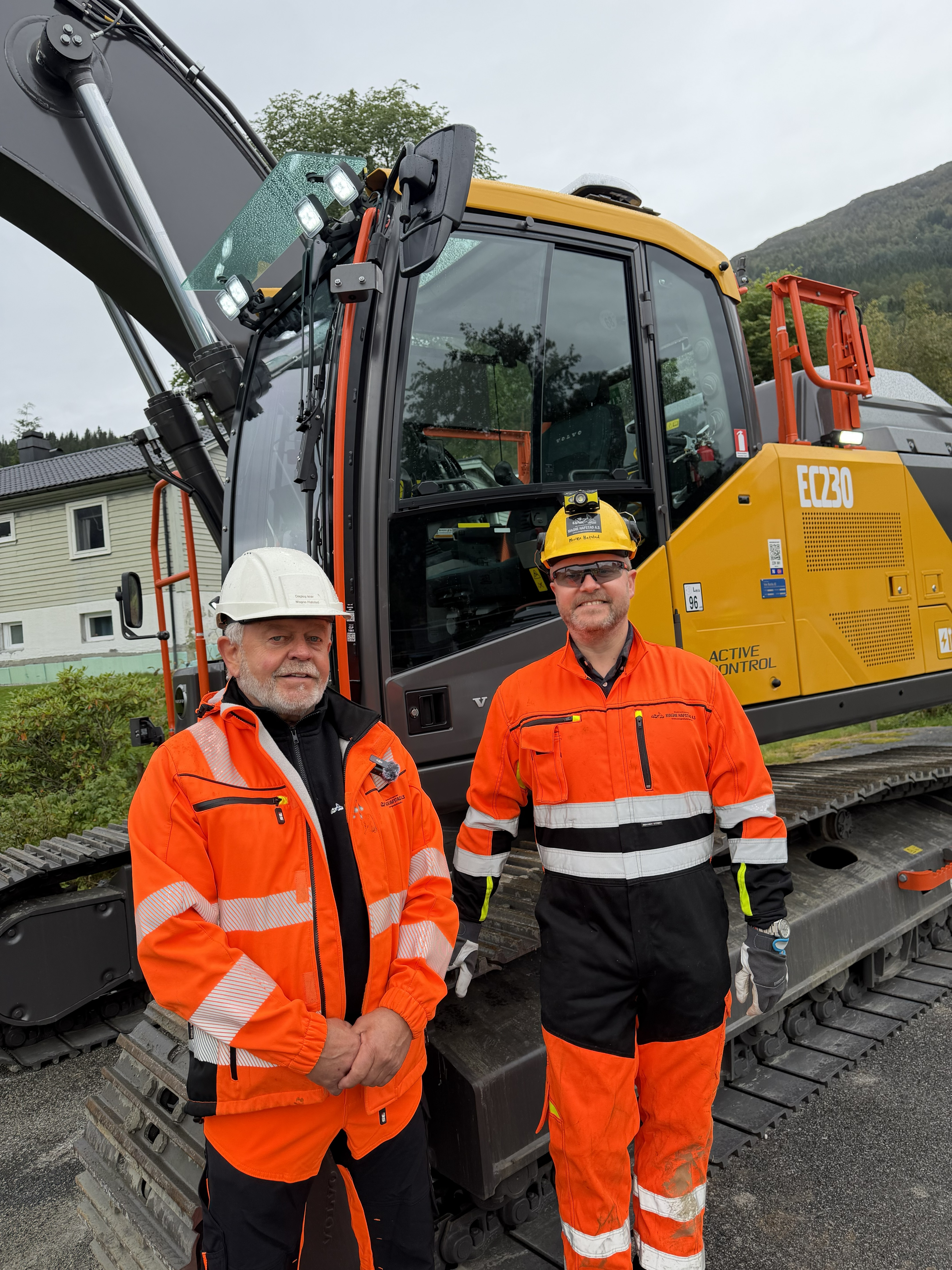 Morten og Magne Hafstad foran en elektrisk Volvo EC230 gravemaskin i Førde