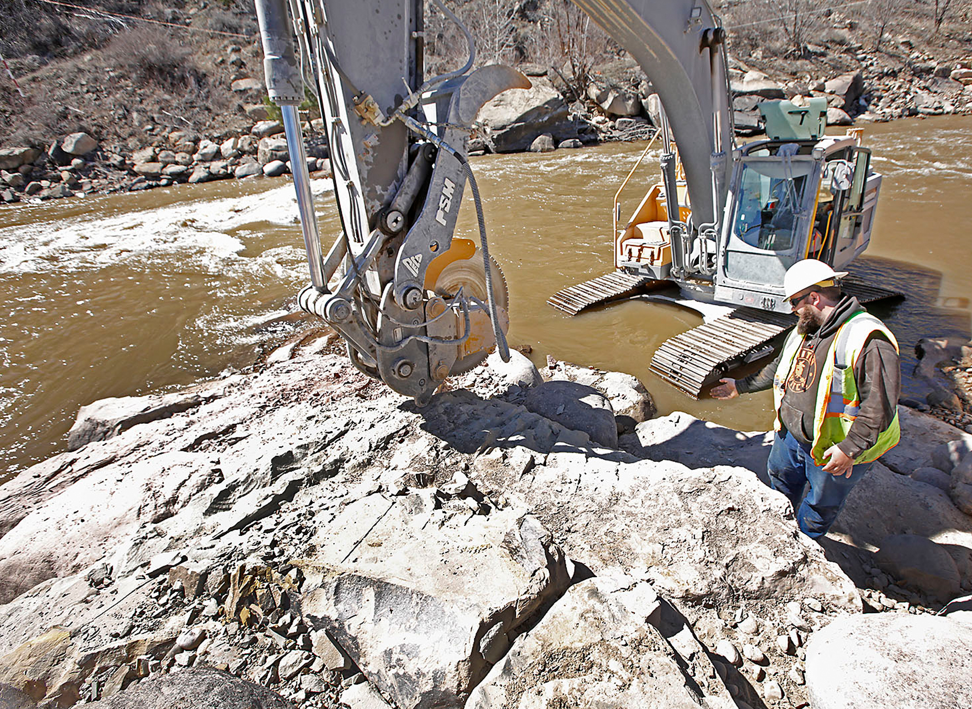 Volvo excavator saws through rock with percision at Durango Whitewater Park in Colorado